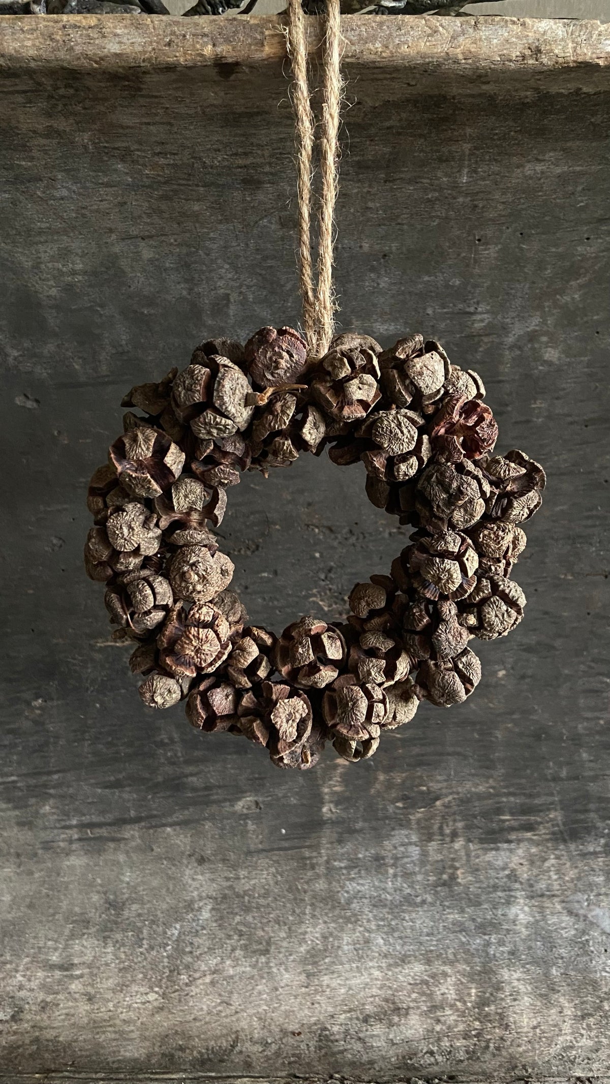 Krans rota pine S van 15 cm aan een jute lus
